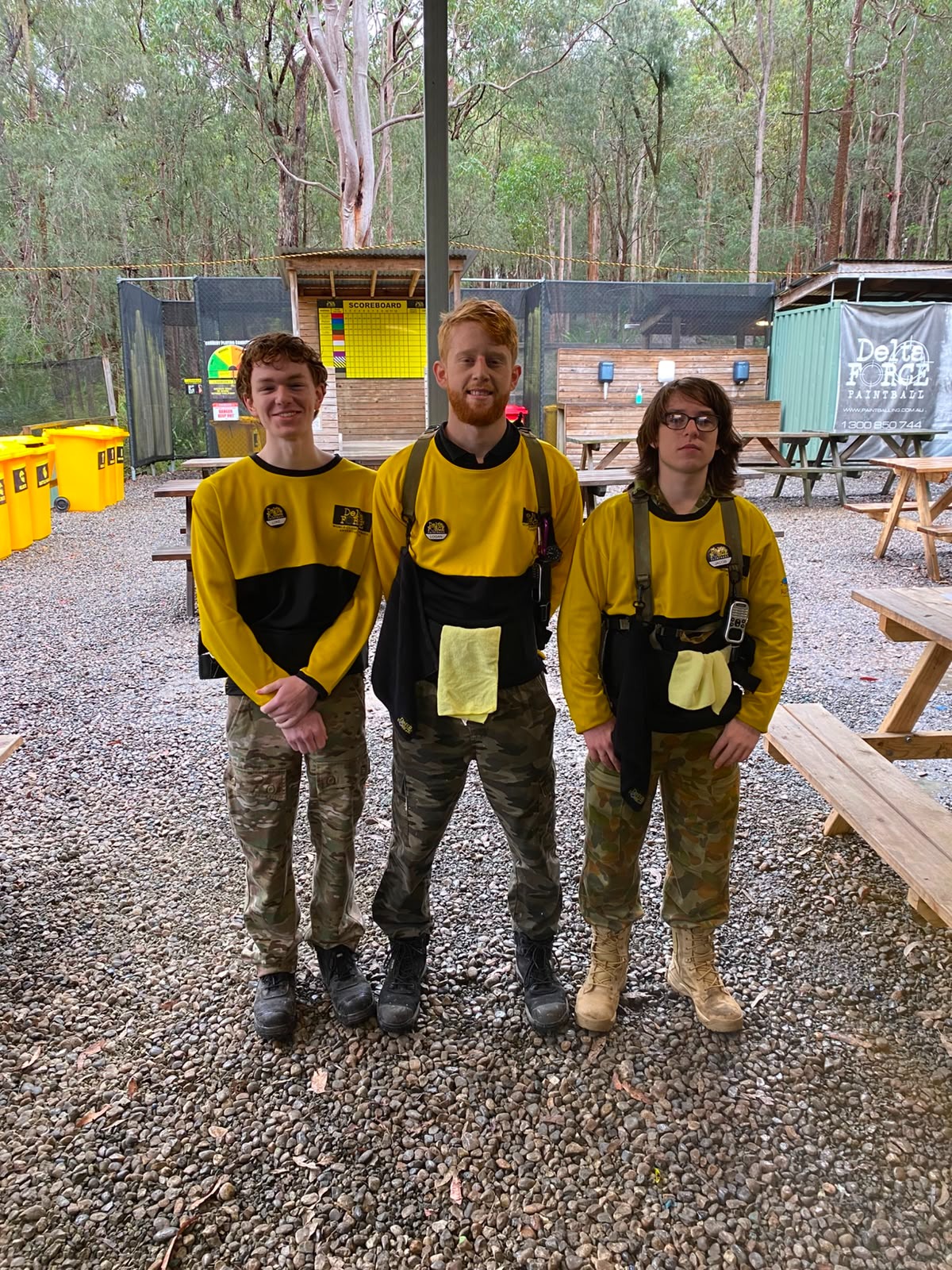 Three Delta Force marshals standing together at a woodland paintball centre